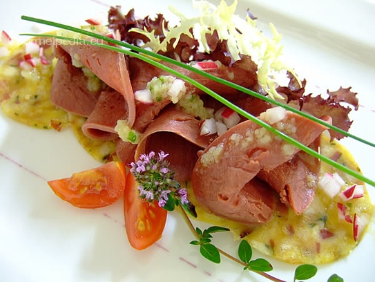 Lengua salada sobre carpaccio de albóndigas con vinagreta de rabanitos