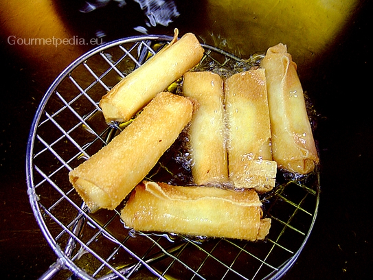 Die Frühlingsrollen aus dem Frittierfett holen