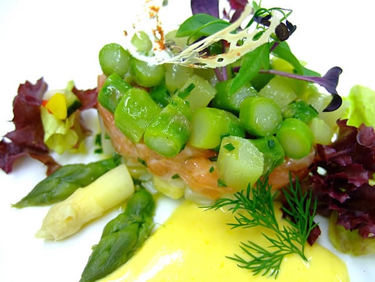 Tartara di salmone con insalata d'asparagi e salsa olandese su insalata estiva