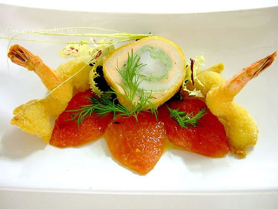 Roll of sole and salmon on oven-cooked tomatoes with fried king prawns in coconut