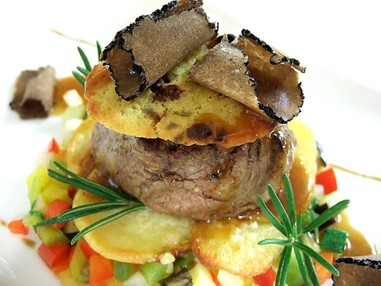 Filet de bœuf en croûte au foie gras au gratin avec truffes noires et pommes de terre éventail sur légumes sautés