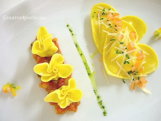 Ravioli ripieni al formaggio con burro fuso su ragù di pomodori sauté