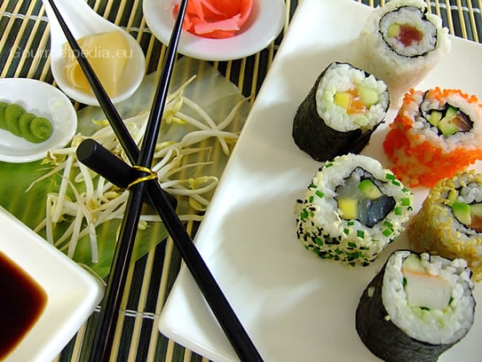 Ura-Maki und Maki-Sushi serviert mit eingelegten Ingwer, Sojasauce und Wasabipaste