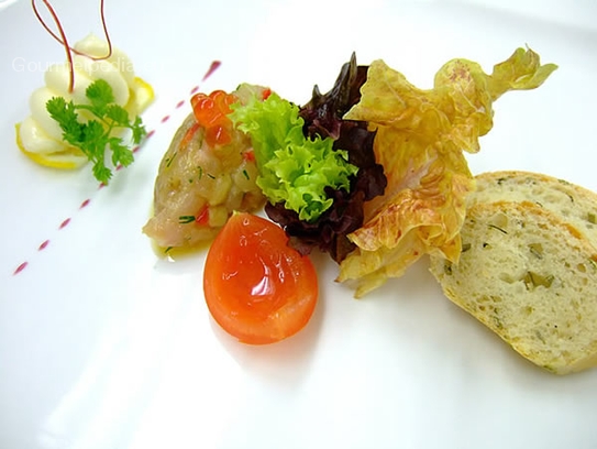 Tartara di trota con caviale e burro al limone su insalatina marinata e pane all'anice