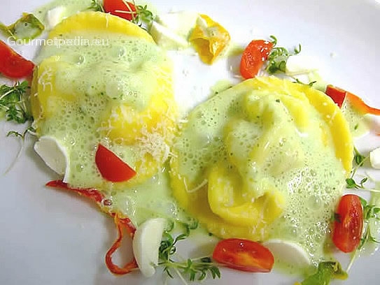 Ravioli ripieni di pomodorini e mozzarelline su salsa al basilico