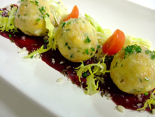 Albóndigas de queso con mantequilla derretida y parmesano sobre carpaccio de remolachas