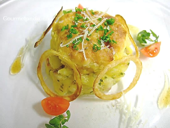 Sauteed cheese dumplings on potato salad with fried onion rings