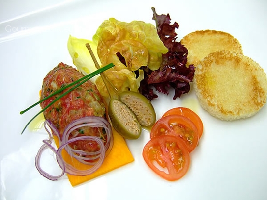 Tartara di filetto di manzo con crostini su insalatina marinata