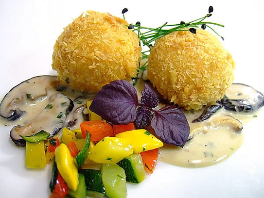 Albondigas de queso Camembert fritas sobre crema de setas shiitaki con ragú de verdura