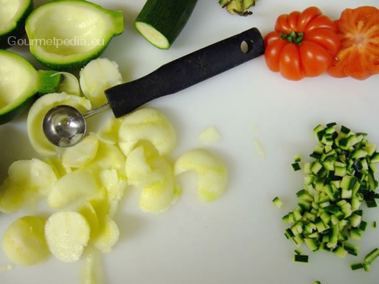 Die kleinen Zucchini halbieren, aushöhlen und Reste mit der Tomate und der Mozzarella in kleine Würfel schneiden