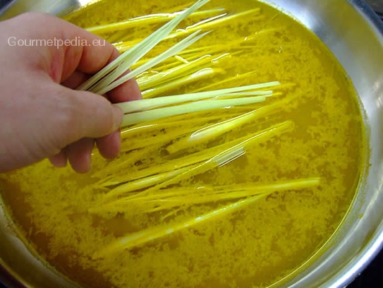 Die geschnittenen Zitronengrasspalten in das Curry-Wasser einlegen und ca. 5 Minuten leicht köcheln lassen