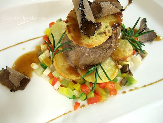 Filet de bœuf en croûte au foie gras au gratin avec truffes noires et pommes de terre éventail sur légumes sautés