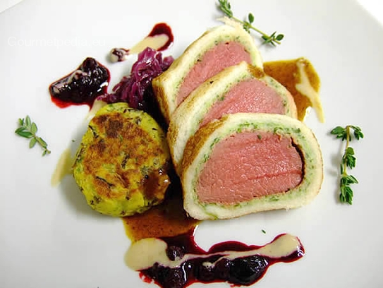Fillet of venison in a crisp bread crust on yellow boletus sauce with cranberries