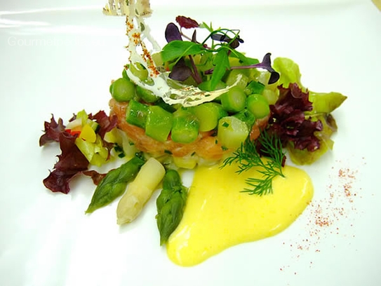 Tartara di salmone con insalata d'asparagi e salsa olandese su insalata estiva