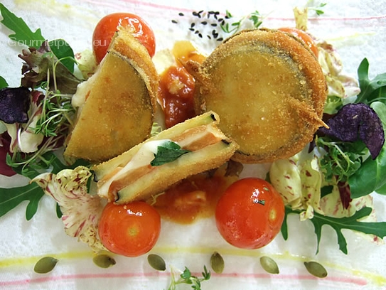 Empanadillas de berenjenas, rellenos de tomates, mozzarella y albahaca, sobre tomatitos salteados