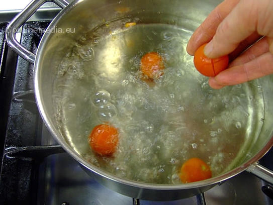 Die vorbereiteten Kirschtomaten ins kochende Wasser legen bis die Haut sich zu lösen beginnt