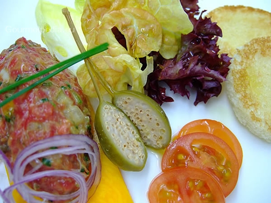 Tartara di filetto di manzo con crostini su insalatina marinata