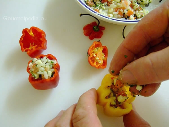 Die vorbereitete Reisfüllung in die Mini-Paprika einfüllen