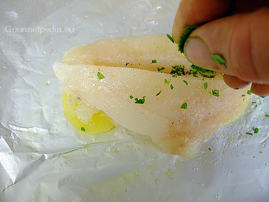 Das Fischfilets mit Gewürzen und Petersilie abschmecken