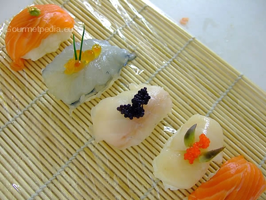 Die Nigiri-Sushi mit Kaviar und Garnituren fertigstellen