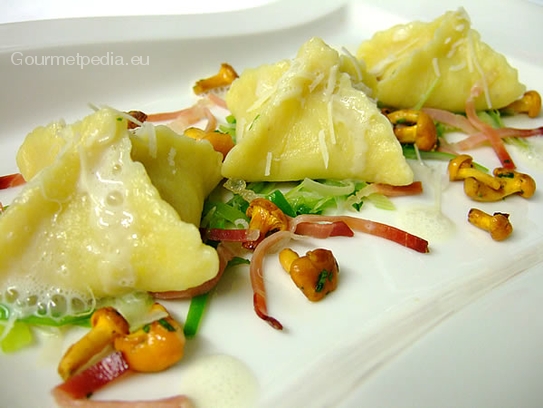 Ravioli di patate ripieni di finferli su porro sauté e striscie di speck