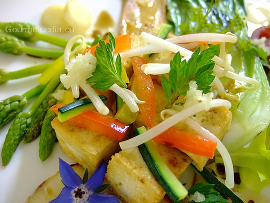 Tofu en des poêlés sur pak-choi, asperges sauvages, cèpes et germes de soja