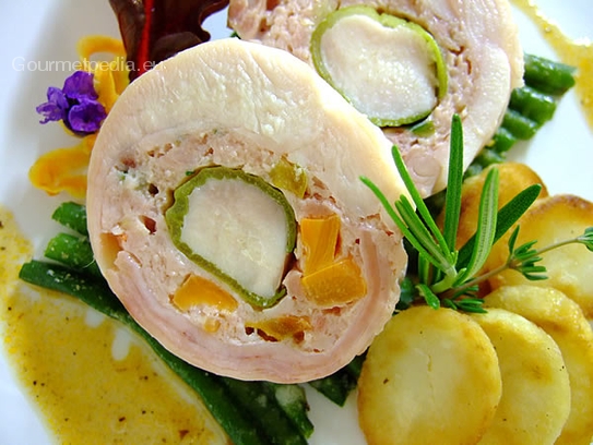 Stuffed rabbit roll on a beet of baked green beans with roast potatoes