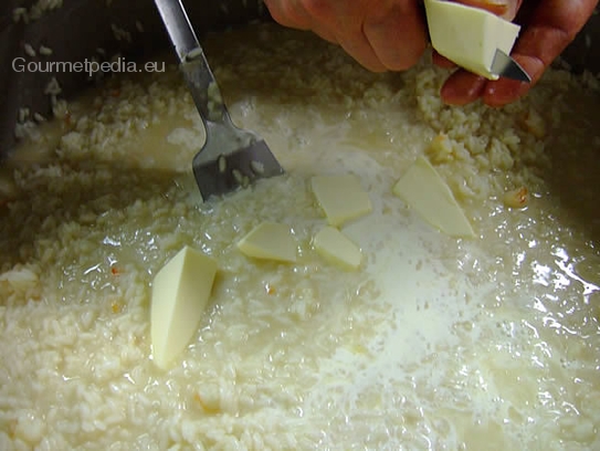 Den Risotto mit Butterstücken aufmontieren und etwas Sahne aufgießen