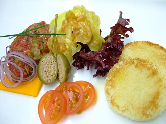 Tartara di filetto di manzo con crostini su insalatina marinata