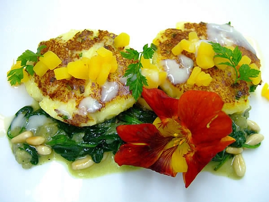 Pastelitos de patata y calabaza sobre espinacas salteadas con piñones