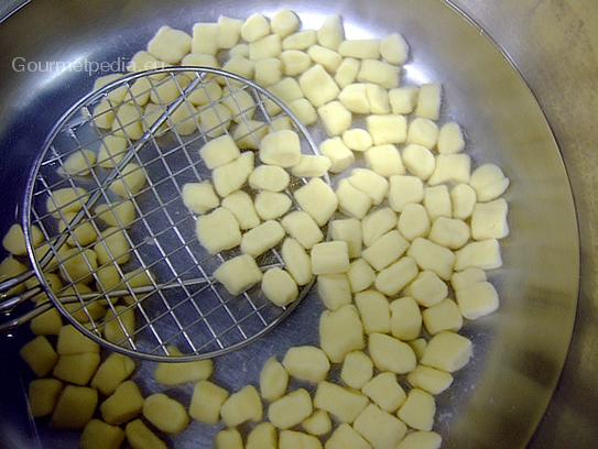 Die Kartoffelnocken aus den Kochwasser nehmen und in Eiswasser abschrecken