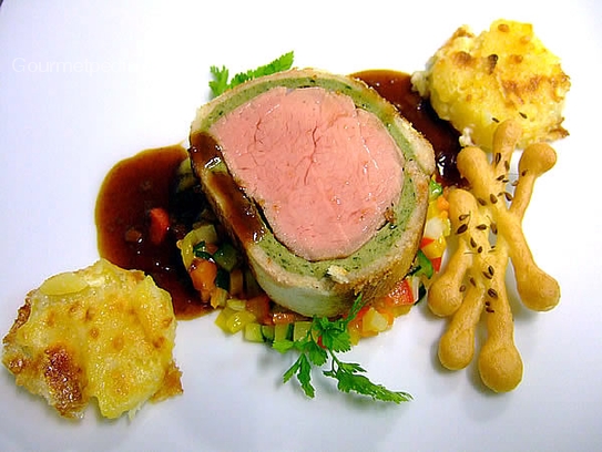 Roast filet of veal in bread-herb coat on gratinated potatoes, vegetables and red wine shallots sauce