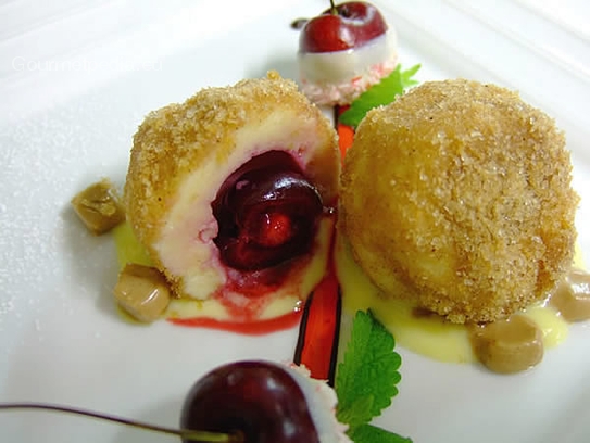 Cherry dumplings of cottage cheese with nougat on vanilla sauce