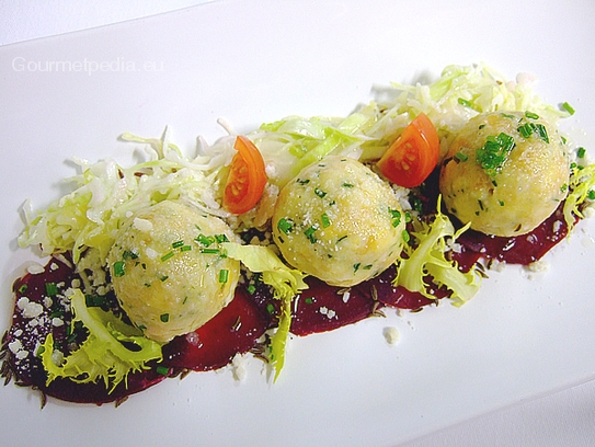 Serviervorschlag von Käseknödel auf rote Bete Carpaccio