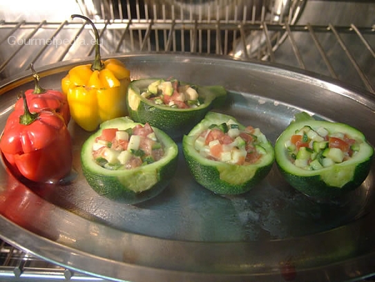 Die gefüllten Mini-Paprika und Zucchini auf einen gefetteten Backblech im Heißluftofen garen