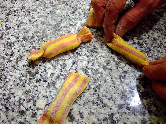 Die Teigblätter zu kleinen Bonbons falten und die Enden leicht abdrehen