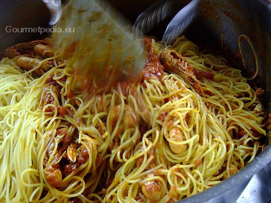 Die Spaghetti, Al Dente gekocht, in die Sauce geben und mit weiterer Petersilie verrühren