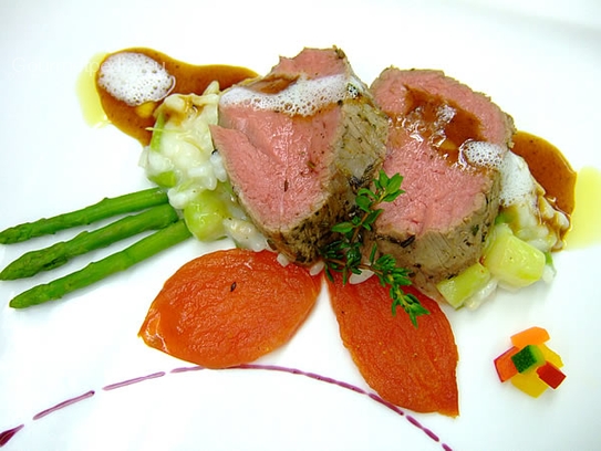 Filete de ternera asado rosa sobre arroz cremoso con espárragos y tomates al horno