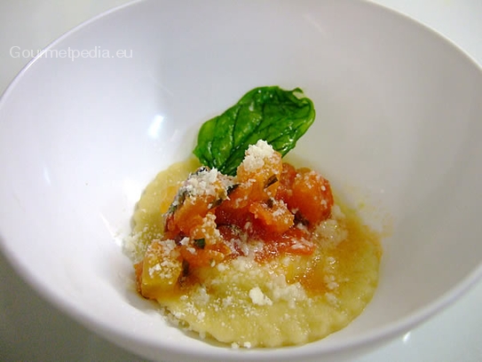 Raviolo relleno de verdura sobre crema de ave