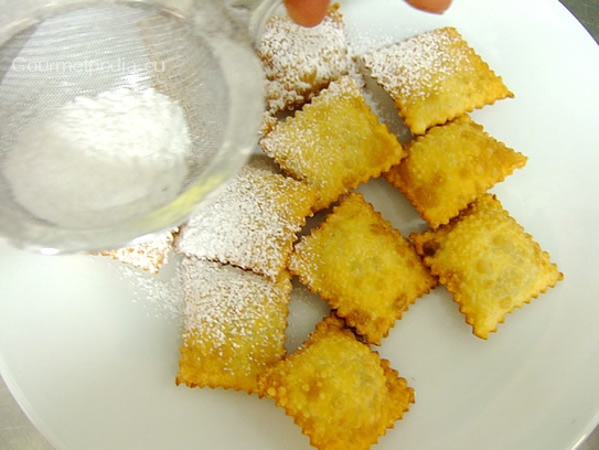 Die noch heißen Ravioli mit Staubzucker bestreuen und servieren