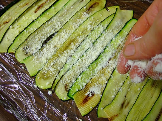 Frisch grob geriebenen Parmesan über die Zucchini streuen