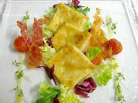 Pan-fried Wonton ravioli, filled with fresch goat cheese on marinated salads and crispy bacon