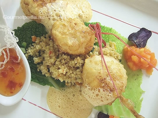 Brochette of scallops in tempura batter for deep frying on vegetables couscous with lobster sauce