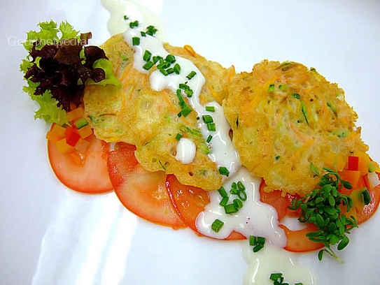 Pastelitos de zanahoria y courgette sobre carpaccio de tomates y salsa de cebollina