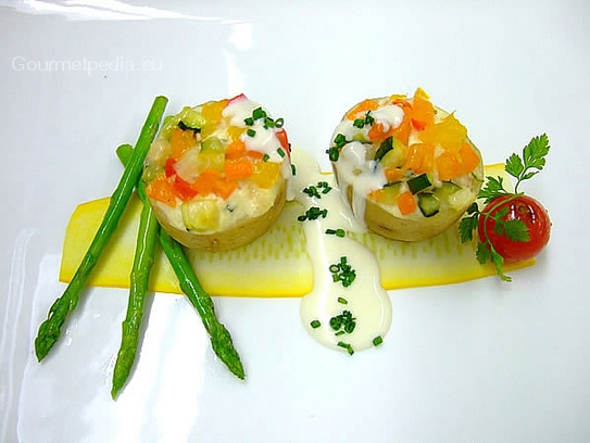 Patatas rellenas con verduras y queso fresco al gratén sobre espárragos y salsa de cebollina