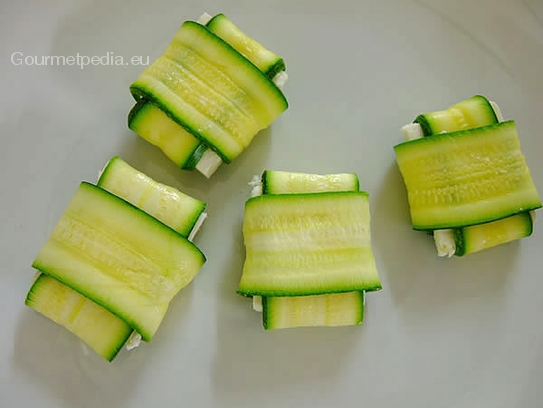 Den Käse rundum in den Zucchinischeiben einpacken