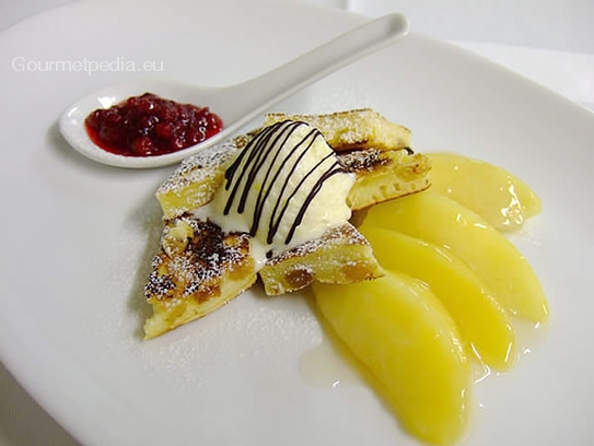 Browned omelette with cranberries and vanilla ice-cream on warm stewed apples