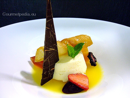 Timbale de chocolat blanc au cœur de noisettes sur la sauce de fruits en gelée