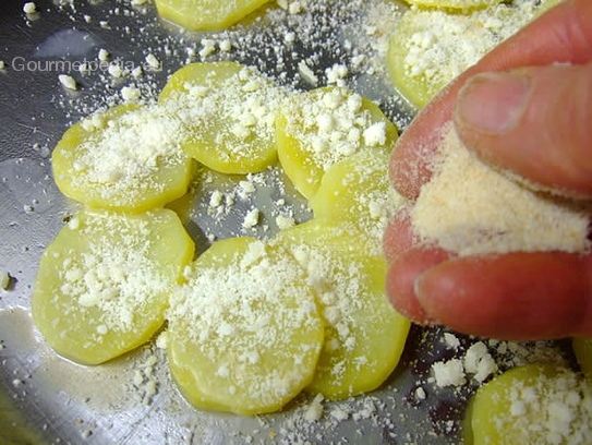 Die Kartoffelscheiben mit geriebenen Parmesankäse bestreuen