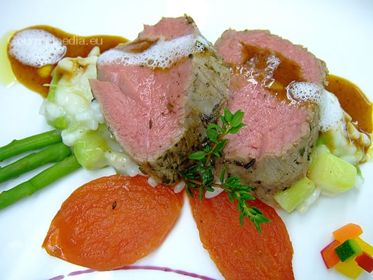 Filete de ternera asado rosa sobre arroz cremoso con espárragos y tomates al horno